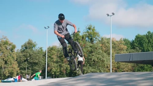 Young Adult Doing BMX Bike Trick at Skate Park