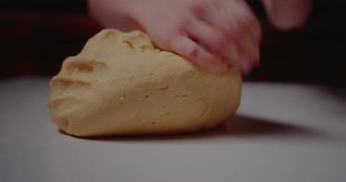 Hands kneading dough for baking