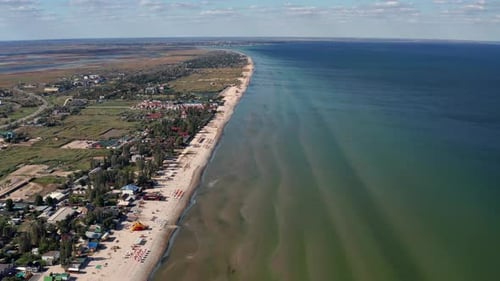 Beautiful flight in summer over the beach. People are resting near the sea.