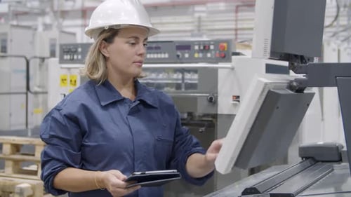 Focused Middle Aged Technician Operating Industrial Machine
