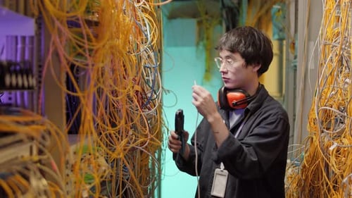 Young Adult Working on Cables in Data Center