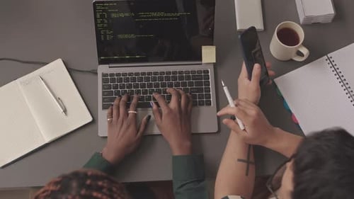 Draufsicht von Programmierern, die mit Programmcodes auf dem Laptop arbeiten