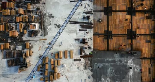 Vuelo sobre el sitio de construcción del centro comercial, con grúa y andamios. Con personas en