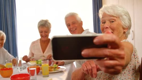 Seniors Taking Group Selfie at Table