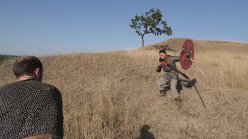 Two Men Engaged in Sword Fight on Hill