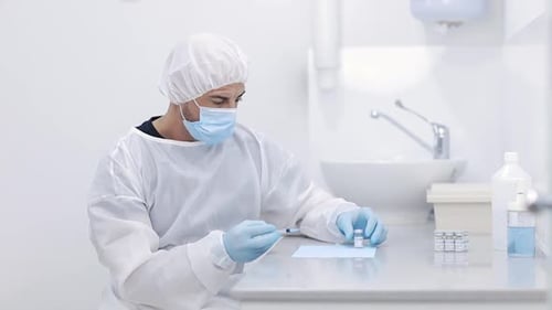 Crop doctor filling syringe with drug in hospital