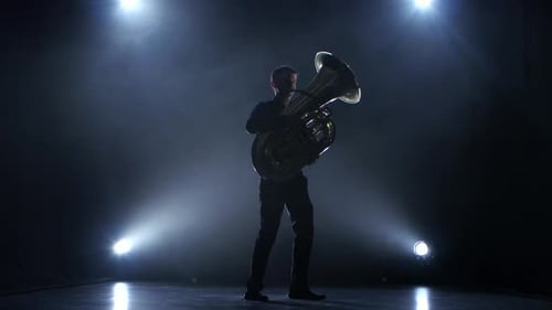 Instrumentalist Plays on Wind Instrument Classical Melody. Studio in Smoke