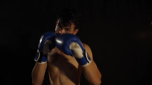 Shirtless Boxer Punching in Boxing Gloves