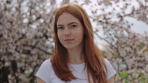 Woman with Charming Smile Standing in Blooming Park Looking at Camera