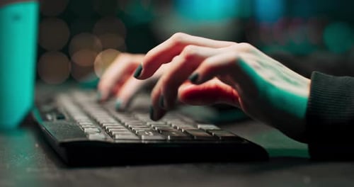Close-up de uma jovem hacker feminina mãos escrevendo malware em um teclado de computador em