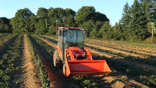 Tractor Driving Through Farm Field