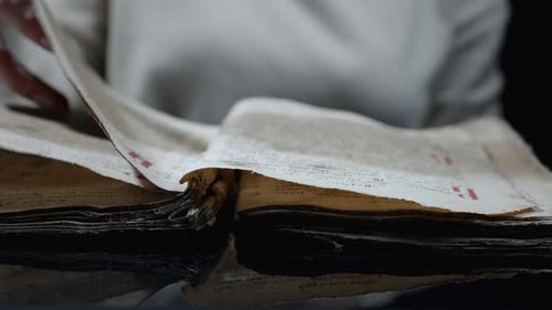 Hand Turns Page of Very Old Book