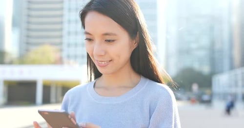 Young Woman Using Smartphone in City Environment
