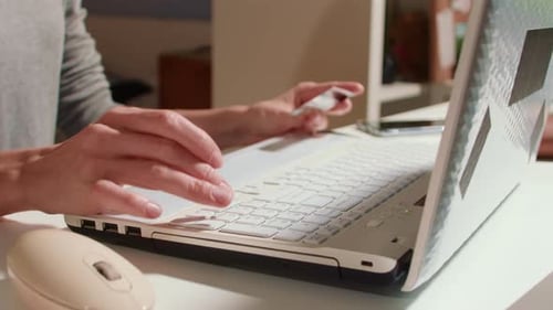 Frau bezahlt online mit Kreditkarte und Laptop