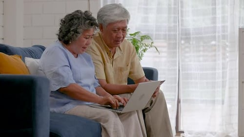 Senior Couple Using Laptop in Living Room
