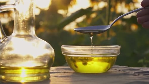 Golden Oil Being Poured Into Bowl in Sunlight