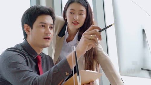 Two Business People Talk Project Strategy at Office