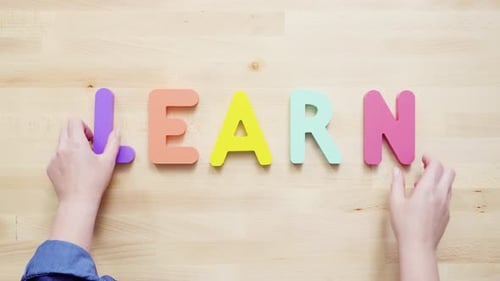 Colorful Foam Letters Spell LEARN on Wooden Table