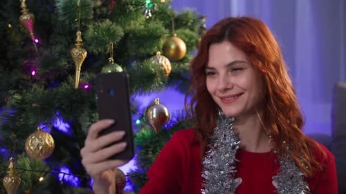 Woman Video Chatting by Decorated Christmas Tree