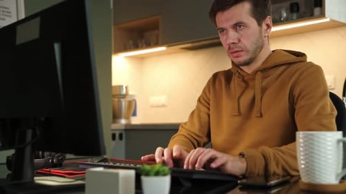 Man Works at Home Office Remotely Using Computer