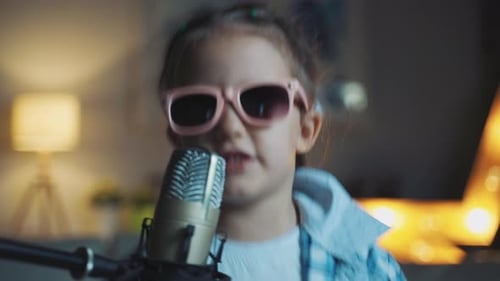 Child Singing into Microphone with Sunglasses Indoors