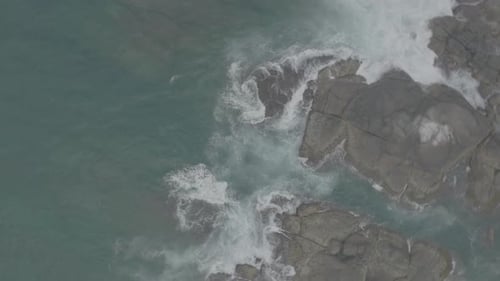 Waves Crash Against Rocks in the Ocean