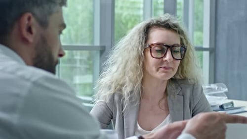 Geschäftsmann und Geschäftsfrau diskutieren Dokument auf Tablet