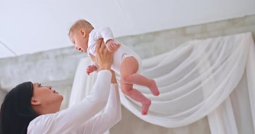 Loving Mom Holds Crying Smiling Baby
