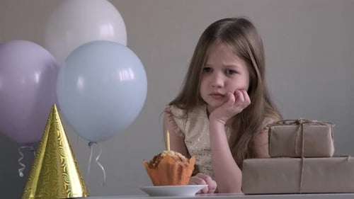 Sad Girl with Cupcake at Birthday Party