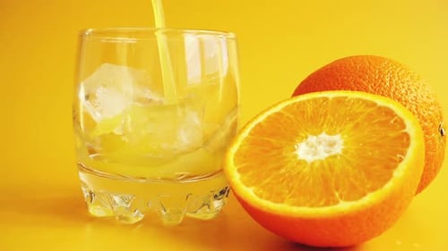 Refreshing Orange Juice Poured Into Glass with Ice