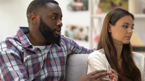 Man Talking to Unhappy Woman on Couch