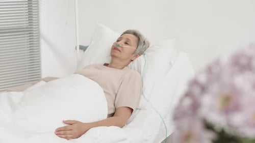Adult Patient Lying in Hospital Bed with Oxygen