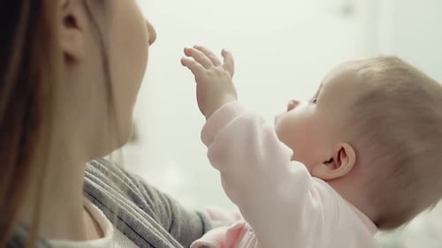 Loving Mother Holding Cute Baby Close