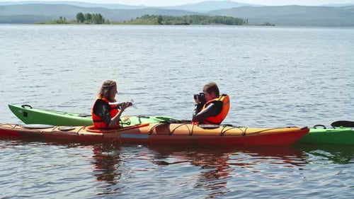 Kayaking Couple on a Calm Lake, Taking Pictures