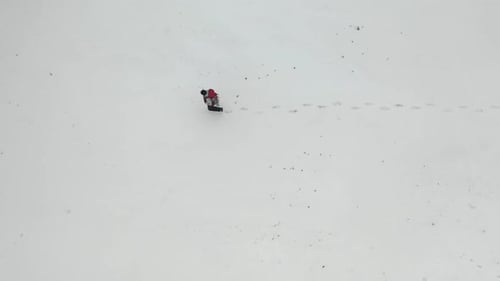 Top Aerial View - Lonely Human with Backpack Walking By Snow Desert