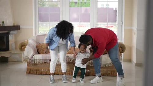 Wide Shot Happy African American Father Mother and Toddler Son Dancing in Living Room at Home