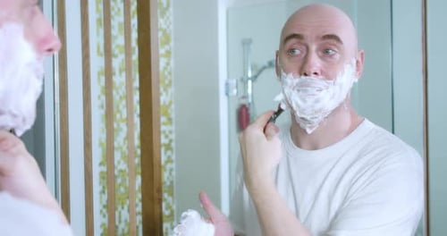 Middleaged is Shaving Using Disposable Razor in Bathroom Closeup Side View