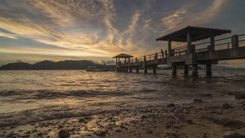 Timelapse sunset of a jetty with a lot of stone at the beach