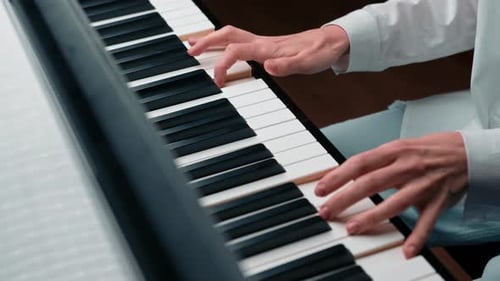 Close-up: a woman sensually plays the piano
