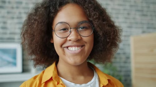 Close-up Slow Motion Portrait of Cheerful Young Woman with Curly Hair Smiling