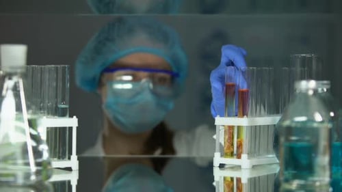 Assistant de laboratoire étudiant un échantillon de viande avec une loupe, analyse des helminthes