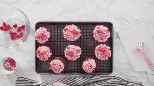 Flache Lage. Schritt für Schritt. Cupcakes aus rotem Samt mit schokoladenroten Herzen und Küssen verzieren.