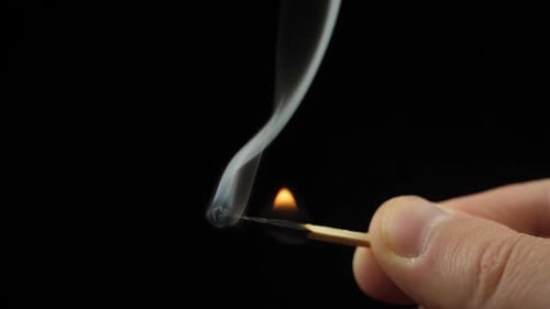 Smoke from Match lighting and burning till the end and finally disappears from the flame on black ba