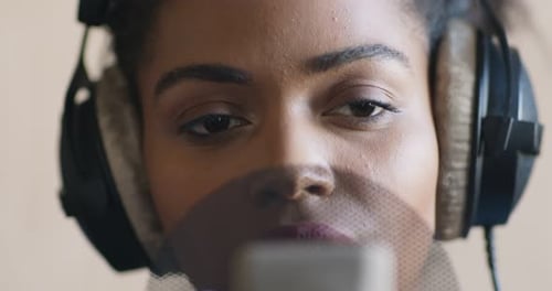Close Up of African American Singer Recording Lyrical Song at Professional Studio