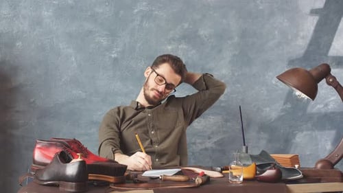 Man Sketches Shoe Design in His Workshop