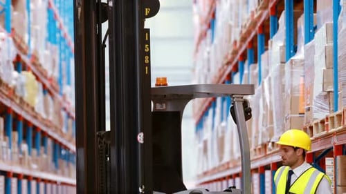 Male warehouse worker checking stock for shipping