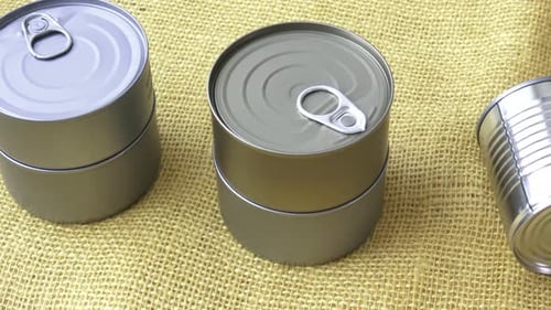 Alimentos enlatados en latas sobre yute amarillo