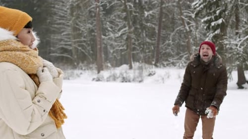 Husband Throwing Snowball at Wife