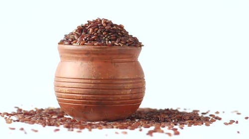 Pot of Raw Red Rice on White Background
