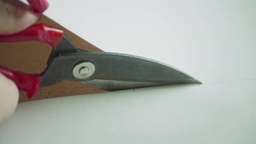 Close Up Sharp Professional Scissors in the Hands of a Tailor Cut a Sheet of Paper Along the Line